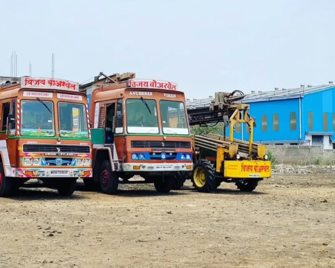 Vijay Borwell drilling trucks and tractor-mounted rig parked at the yard